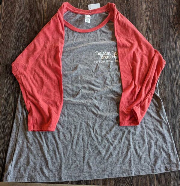Red and gray Baseball Tee laid out on a wooden surface.