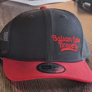 A Black/Red Trucker Baseball Cap with "balsam lake brewery" embroidered on the front.