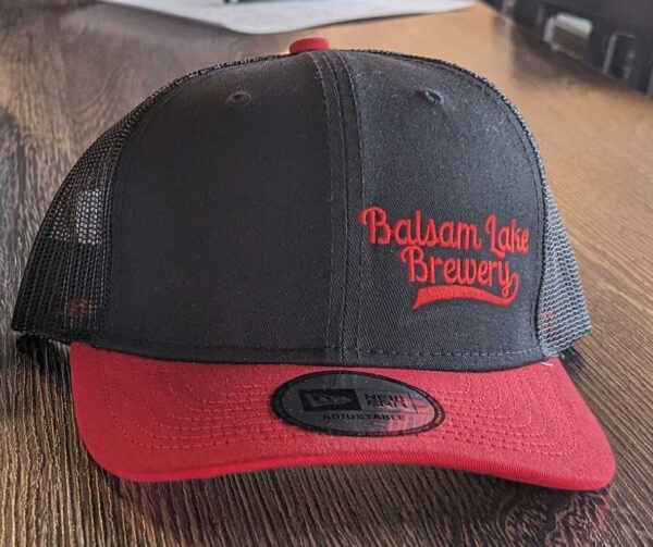 A Black/Red Trucker Baseball Cap with "balsam lake brewery" embroidered on the front.