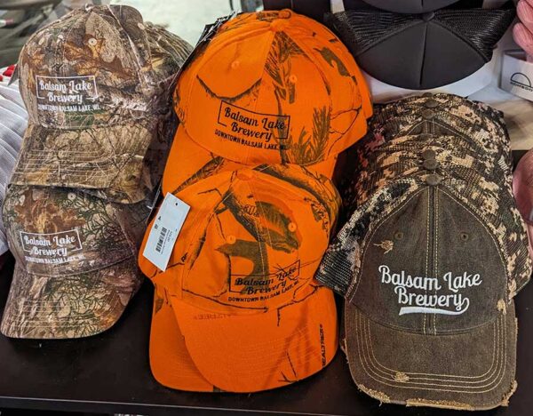 A selection of Blaze Orange Ball Caps in a store.