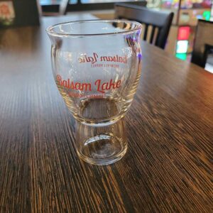 A 5 OZ Taster Glass with the Balsam Lake Brewery logo sits on a table.