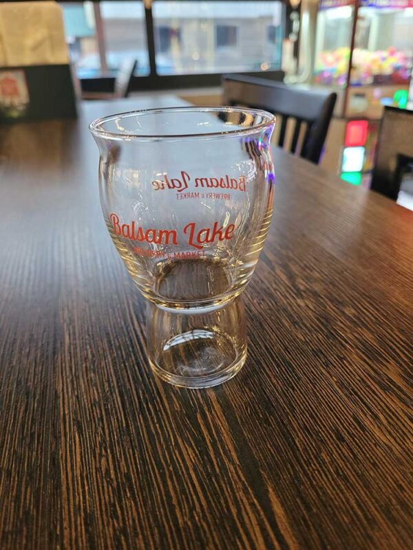 A 5 OZ Taster Glass with the Balsam Lake Brewery logo sits on a table.