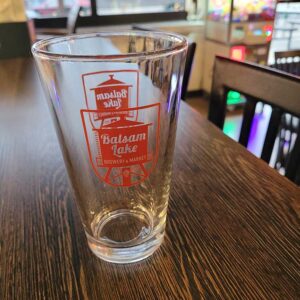 Pint Glass with red logo on bar