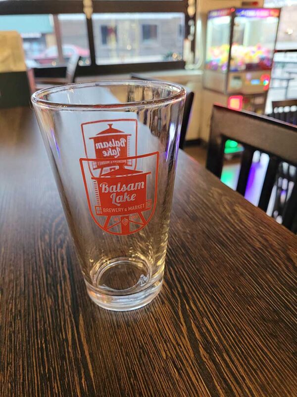 Pint Glass with red logo on bar