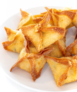 A plate of golden brown fried wontons on a white background.
