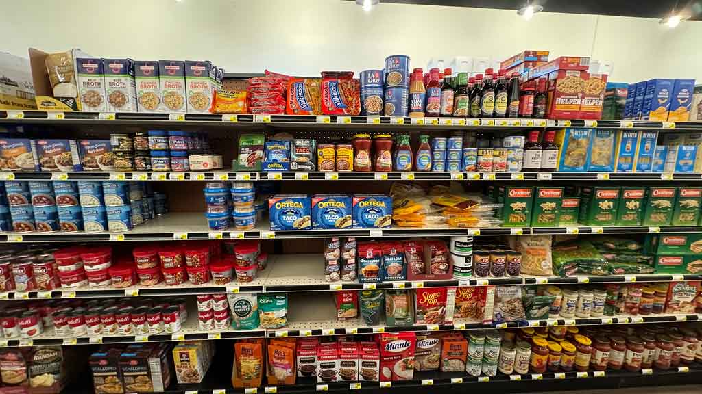 Grocery shelf with assorted can goods