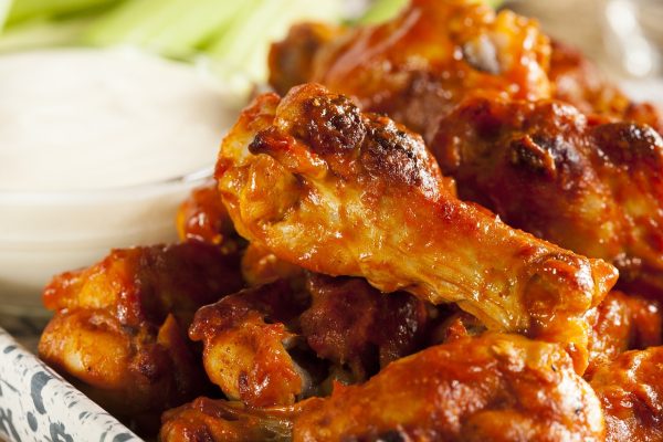 A plate of buffalo wings with celery and dipping sauce is a popular choice at the bar.